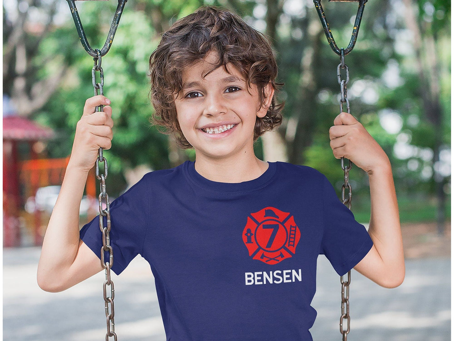 Child wearing the personalized firefighter birthday t-shirt, showcasing the front design with the red Maltese Cross and custom details