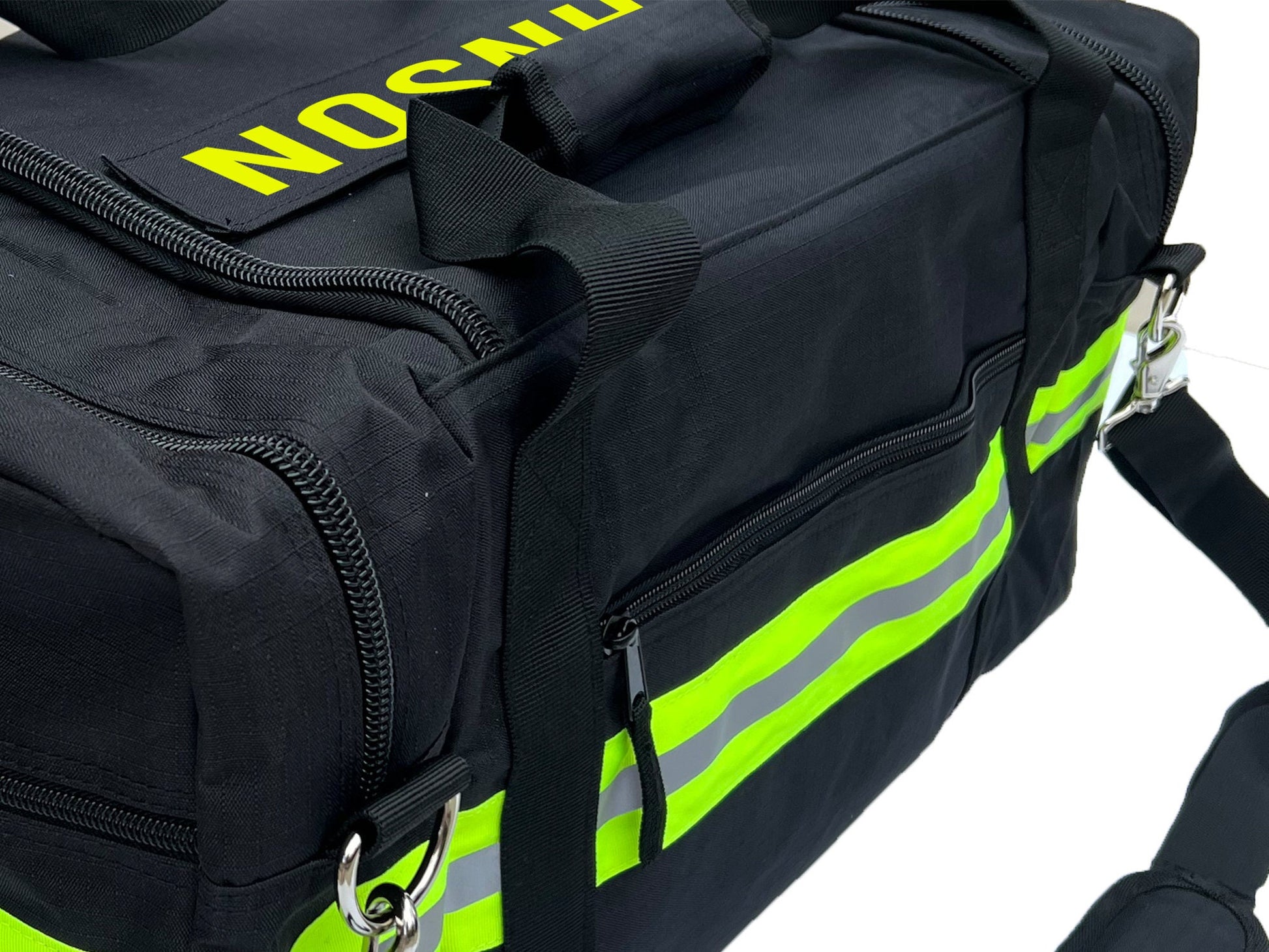Side view of Black firefighter duffel bag showing lime yellow and silver reflective trim and zipper pocket. Personalized text on top of bag.