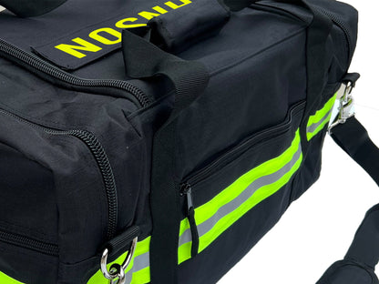 Side view of Black firefighter duffel bag showing lime yellow and silver reflective trim and zipper pocket. Personalized text on top of bag.
