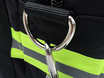 Close up view of heavy duty D ring and snap hook against yellow and silver reflective trim.
