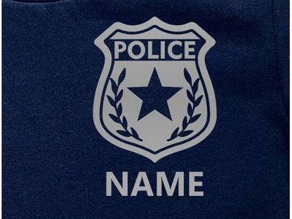 A silver police badge with a five-pointed star and the word 'POLICE' in all caps. The badge is on a navy blue background with the word 'NAME' in all caps below the badge.