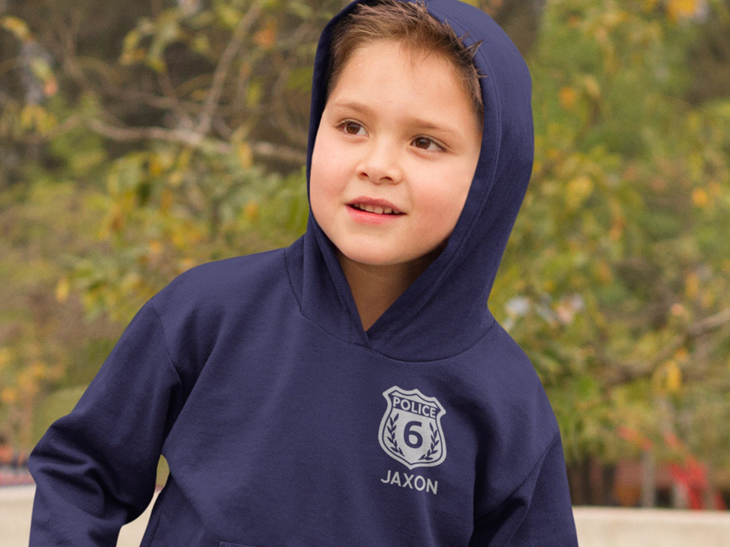A navy blue hooded sweatshirt with a silver police badge design. The badge has the word 'POLICE' and the number '6' inside. The text 'JAXON' is below the badge.