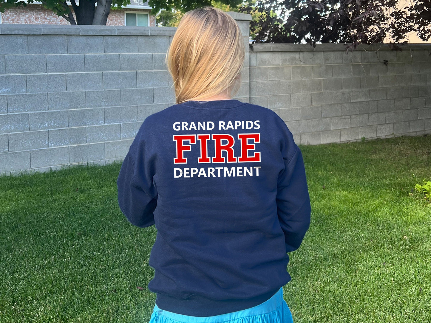 A navy blue sweatshirt with the words 'Grand Rapids Fire Department' printed on the back in white and red lettering.
