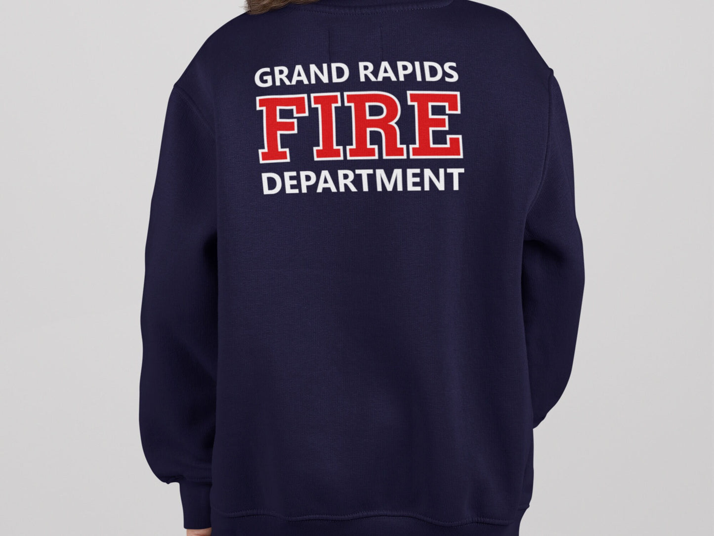 Back view of navy blue sweatshirt with the words 'GRAND RAPIDS FIRE DEPARTMENT' printed on the back in white and red lettering.
