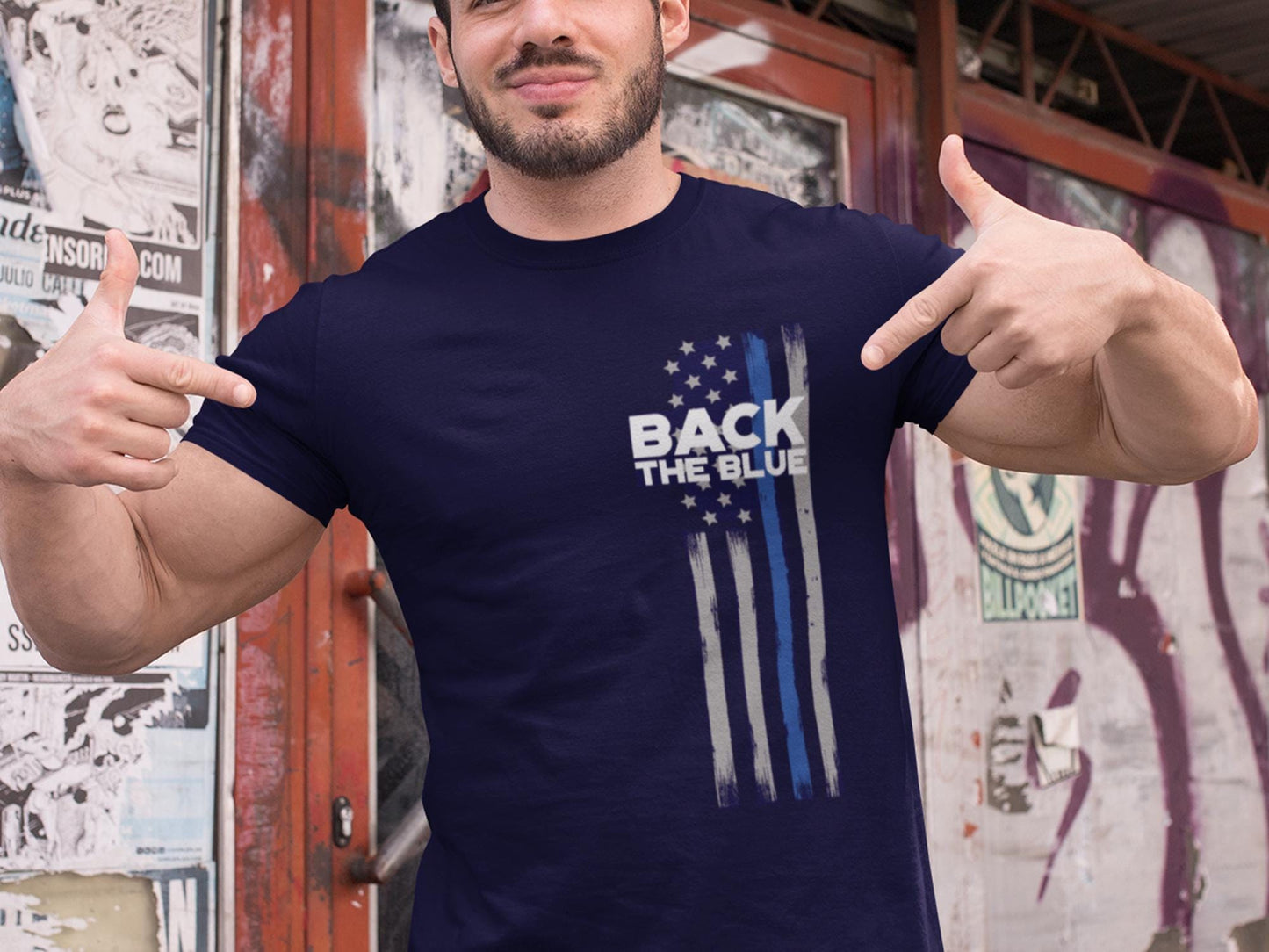 A navy blue t-shirt with a white and blue American flag design. The flag has a thin blue line running down the center. The text 'Back the Blue' is printed in white on the t-shirt.