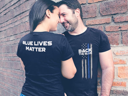 Two people wearing black t-shirts with white text. The person on the left is wearing a t-shirt that says 'Blue Lives Matter'. The person on the right is wearing a t-shirt that says 'Back The Blue' with a thin blue line American flag design.