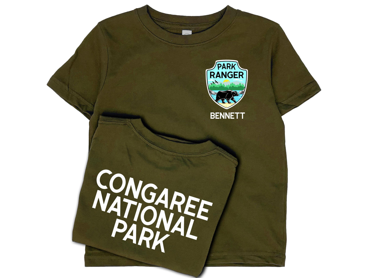 Dark green t-shirt front and back. Front shows a park ranger badge on left chest with mountains, water and black bear and a name written underneath in white. Back shows custom national park name in white.