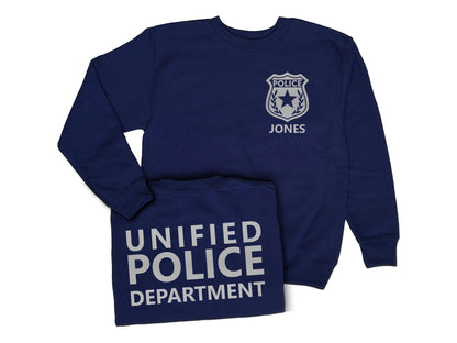 A navy blue youth sweatshirt with a silver police badge on the front that says 'POLICE' and 'JONES'. The back of the sweatshirt says 'UNIFIED POLICE DEPARTMENT' in silver text.