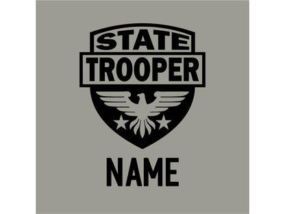 A black graphic design shows closeup of a shield with an eagle and stars. The text 'STATE TROOPER' is at the top of the shield and the text 'NAME' is below the shield.