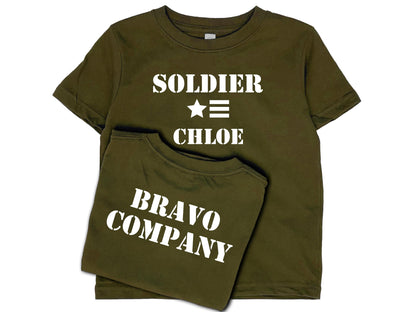 Army green short sleeve t-shirt with 'Soldier' in white text, a star and 3 horizontal stripes underneath, and under that the name 'Chloe'. The shirt back reads 'Bravo Company' in white text.