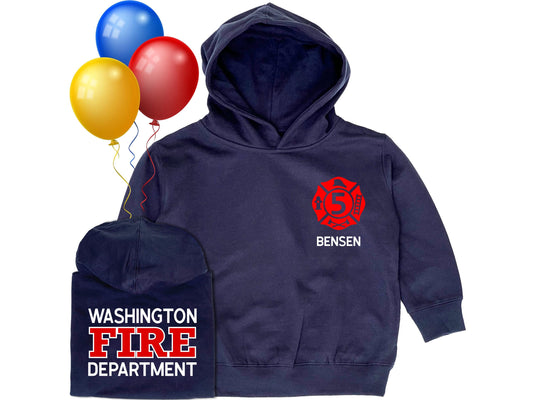 Navy blue hooded sweatshirt in children sizes with custom red Maltese Cross on the front. Maltese Cross contains a custom number representing the child's age. Hoodie has hidden side pockets on both sides. The child's name is under the Maltese Cross. A folded hoodie shows the back side with a custom fire department name with "Fire" and "Department" underneath. Three colorful balloons indicate a birthday theme.