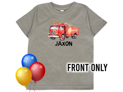 Front view of child's gray t-shirt with red watercolor design fire truck on the center chest. The child's name underneath represented by "Jaxon".