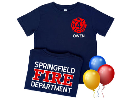 Navy blue kid’s birthday firefighter t-shirt with red Maltese cross that includes the number 4 indicating custom text for child’s age. Name is written below the badge and custom fire department printed on back in red and white text.