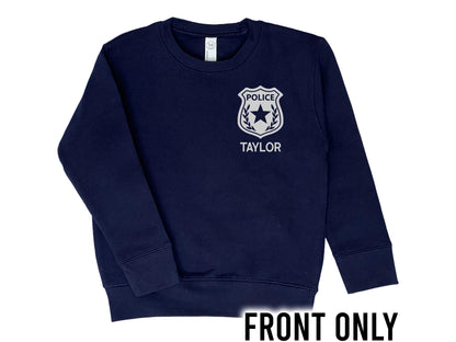 Front view of navy blue crew neck sweatshirt with silver police badge on left chest with the name 'Taylor' underneath in silver text.