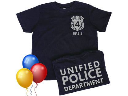 Black short sleeve toddler t-shirt with silver police badge displaying the number 4 and the name Beau underneath. The folded back of the shirt has Unified Police Department in silver text. 3 bright colored balloons represent use for birthday.