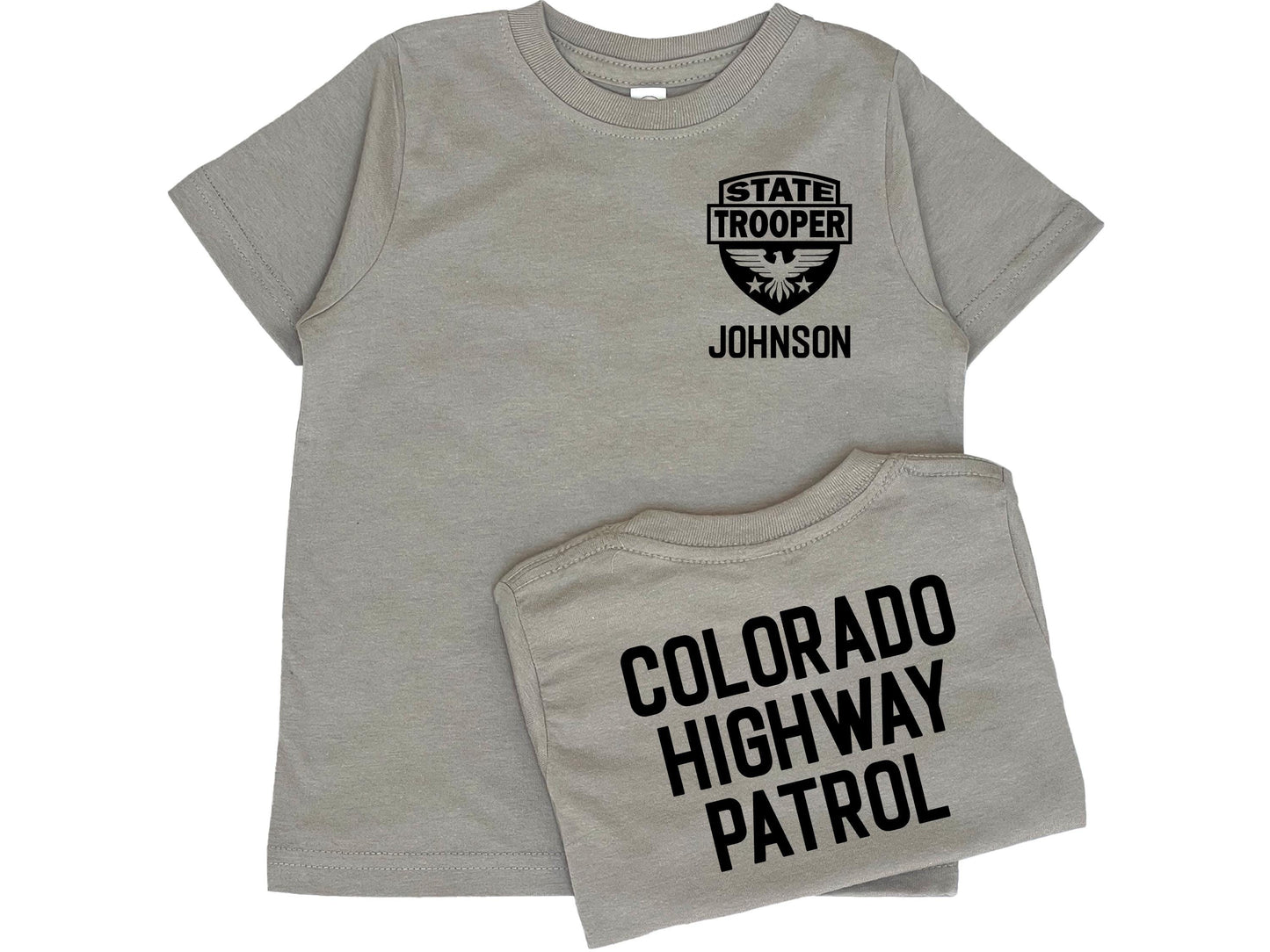 Gray toddler t-shirt with black State Trooper Badge with an eagle on the front left chest. Under the badge is 'Johnson' as a placeholder for custom name. The shirt back has black text 'Colorado Highway Patrol' also a placeholder for custom text.