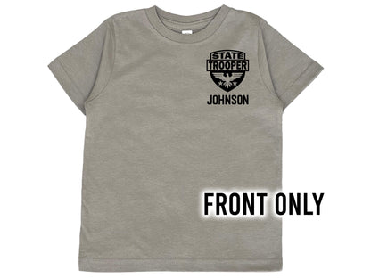 A gray short-sleeved t-shirt with a black graphic of a State Trooper badge with an eagle and the text 'STATE TROOPER' and 'JOHNSON' underneath in black text.