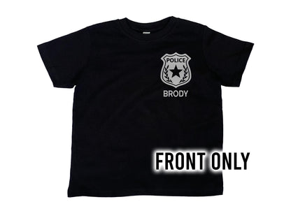 Front view of black t-shirt with silver police badge on left chest and the name 'Brody' underneath in silver text.